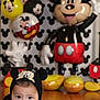 Abraham is registered to the contest to win money with this photo: baby, child, mickey_mouse, hoodie, balloons, party, floor, blanket, indoor, cute, costume, character, celebration, decorations, toy, smiling, face, headwear, playful, young