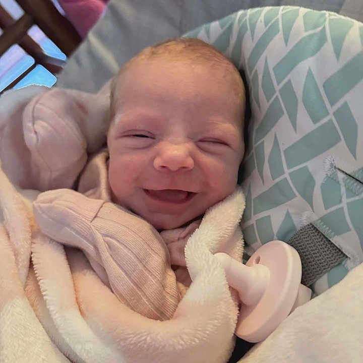 Aubree joined the competition — help win amazing prizes! baby, blanket, child, comfort, cozy, cushion, cute, face, happy, head, indoors, infant, newborn, pacifier, person, resting, sleepwear, smile, soft, wrapped