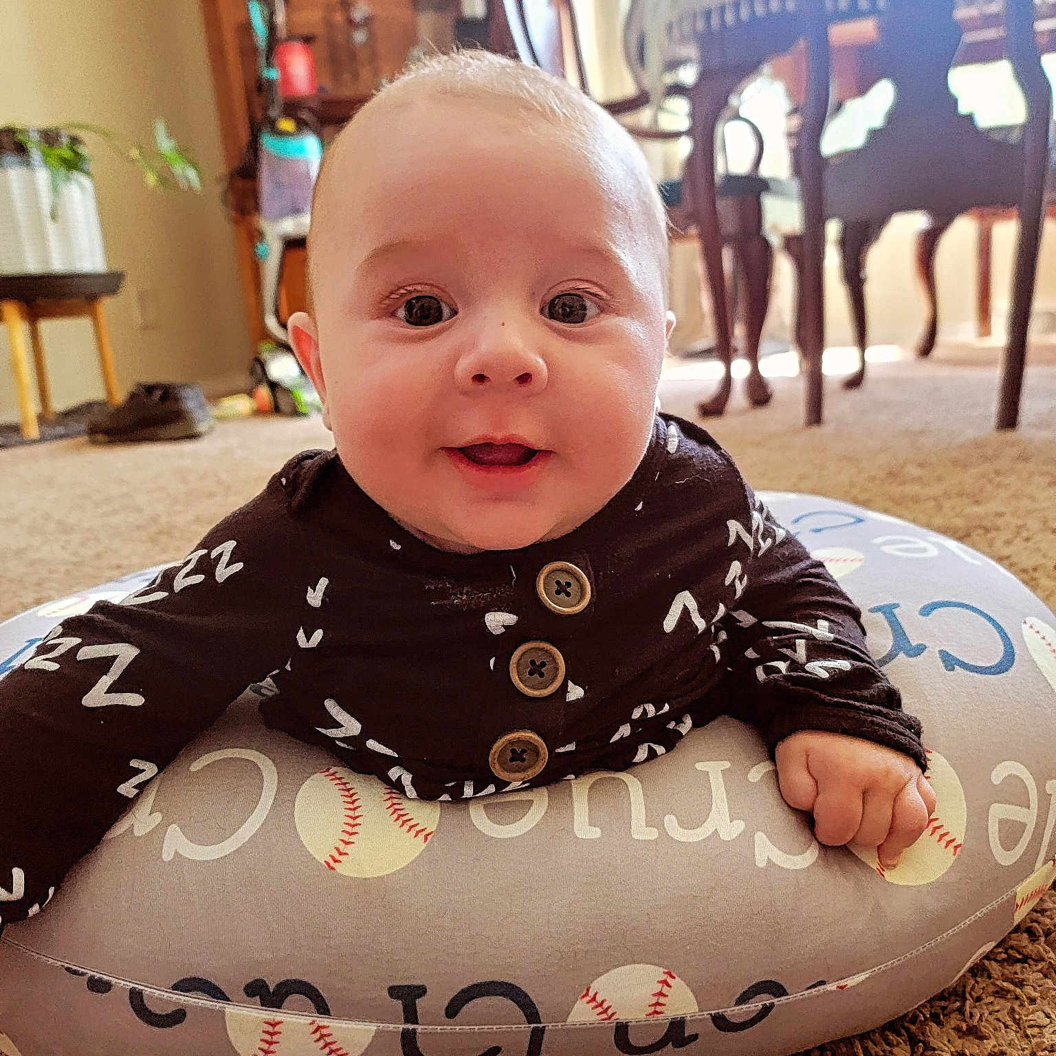 Crue is registered to the contest to win money with this photo: baby, ball, baseball, baseballball, clothing, cushion, diningtable, face, footwear, furniture, head, homedecor, indoors, person, photography, portrait, shoe, sitting, sport, table