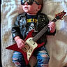 baby, child, leather_jacket, sunglasses, electric_guitar, ripped_jeans, black_boots, towel, rockstar, music, musical_instrument, portrait, indoor, cute, fashion, infant, person, cool, lying_down, accessory