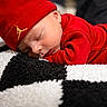 River is registered to the contest to win money with this photo: baby, sleeping, red_clothing, red_hat, blanket, black_and_white, face, peaceful, resting, newborn, soft_texture, closeup, infant, cute, cozy, portrait, child, indoors, warm, relaxed