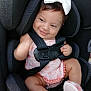 baby, child, car_seat, bow, smile, pink_clothing, fluffy_slippers, happy, infant, seatbelt, cute, portrait, indoors, closeup, sitting, adorable, headwear, baby_girl, soft_fabric, comfort