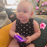 Khaleesi joined the competition — help win amazing prizes! armchair, baby, black_clothing, cat, chair, child, curly_hair, cute, flower_stickers, furniture, indoors, living_room, person, pet, playful, plush, polka_dot, seated, toddler, toy_phone