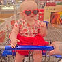Khaleesi is registered to the contest to win money with this photo: accessory, baby, child, clothing, cute, fashion, grocery_store, hand, heart_shaped, indoor, person, red_skirt, retail, shopping, shopping_cart, sunglasses, supermarket, tattoo, toddler, tutu