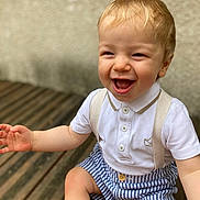 Octave a rejoint le concours — aidez-le/la à gagner de superbes lots ! toddler, child, smiling, happy, blonde_hair, white_polo, striped_shorts, suspenders, sitting, wooden_decking, outdoor, cute, portrait, baby, person, skin, short_sleeves, joy, laughing, casual_clothing
