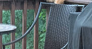 Mr. Meowmers is registered to the contest to win money with this photo: cat, orange_cat, outdoor, wooden_railing, chair, wicker_chair, cushion, grill_cover, greenery, trees, backyard, patio, deck, feline, pet, animal, relaxing, daytime, nature, furniture