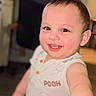 toddler, child, smiling, happy, face, portrait, indoors, cute, baby, sleeveless_shirt, clothing, person, young_child, skin, eyes, mouth, expression, hand, closeup, background_blur