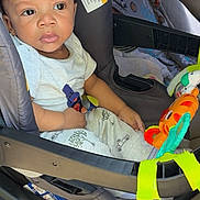 Quante joined the competition — help win amazing prizes! baby, car_seat, toy, blanket, child, infant, seatbelt, car_interior, clothing, cute, portrait, sitting, safety, child_seat, young_child, face, curly_hair, indoors, colorful, bright