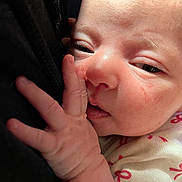 Arabella is registered to the contest to win money with this photo: baby, close_up, hand, face, skin, sleepy, infant, newborn, person, soft_light, cuddling, resting, cute, expression, pink_skin, clothing, fabric, eyes, portrait, tender