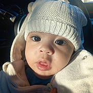 Kalïl a rejoint le concours — aidez-le/la à gagner de superbes lots ! baby, child, hat, knitted_hat, white_clothing, jacket, face, eyes, mouth, hand, car_interior, sunlight, portrait, closeup, cute, warm_light, winter_clothing, infant, cozy, expression