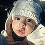 baby, child, hat, knitted_hat, white_clothing, jacket, face, eyes, mouth, hand, car_interior, sunlight, portrait, closeup, cute, warm_light, winter_clothing, infant, cozy, expression