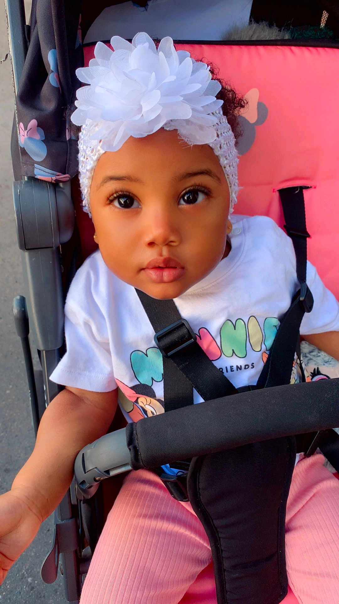 Kayanah a rejoint le concours — aidez-le/la à gagner de superbes lots ! child, toddler, stroller, headband, flower, white, pink_pants, shirt, straps, outdoor, curious, face, eyes, baby, cute, infant, sitting, person, portrait, clothing