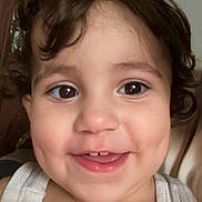 Afiya a rejoint le concours — aidez-le/la à gagner de superbes lots ! toddler, child, smiling, face, portrait, curly_hair, dimples, white_top, indoors, cabinet, brown_eyes, cute, happy, close_up, person, skin, hair, baby, young_child, human