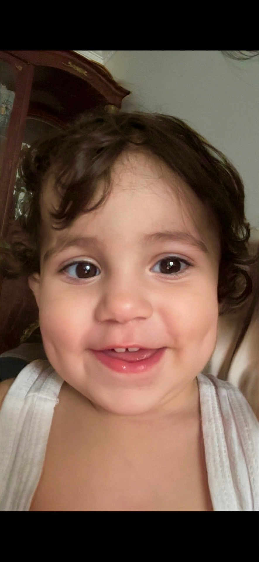 Afiya a rejoint le concours — aidez-le/la à gagner de superbes lots ! toddler, child, smiling, face, portrait, curly_hair, dimples, white_top, indoors, cabinet, brown_eyes, cute, happy, close_up, person, skin, hair, baby, young_child, human