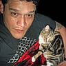 Danny is registered to the contest to win money with this photo: person, cat, tabby_cat, blanket, red, black, checkered, indoor, selfie, face, fur, animal, pet, relaxed, snuggling, tshirt, tattoo, hand, portrait, comfort