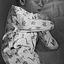 newborn, baby, sleeping, onesie, animal_print, blanket, monochrome, portrait, cozy, infant, peaceful, soft_texture, cute, resting, child, bed, sleepwear, closeup, face, head