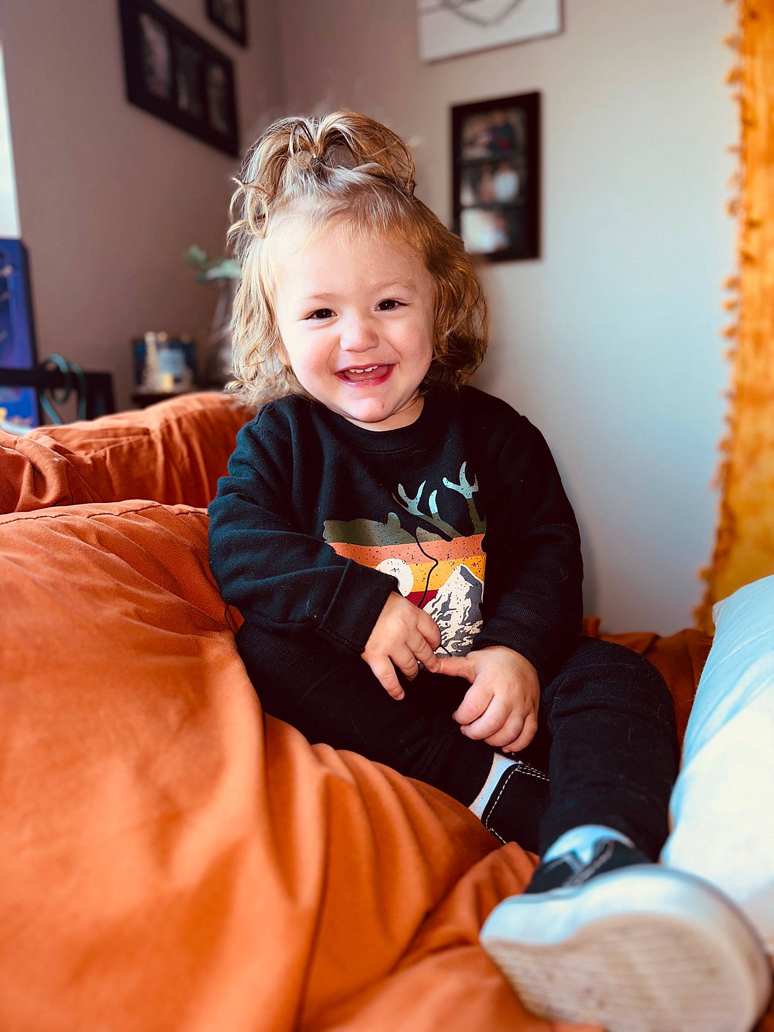 Alex joined the competition — help win amazing prizes! arm, baby_toddler_clothing, blond, child, comfort, couch, curtain, event, facial_expression, flooring, fun, hair, hairstyle, happy, joy, orange, person, picture_frame, sitting, sleeve