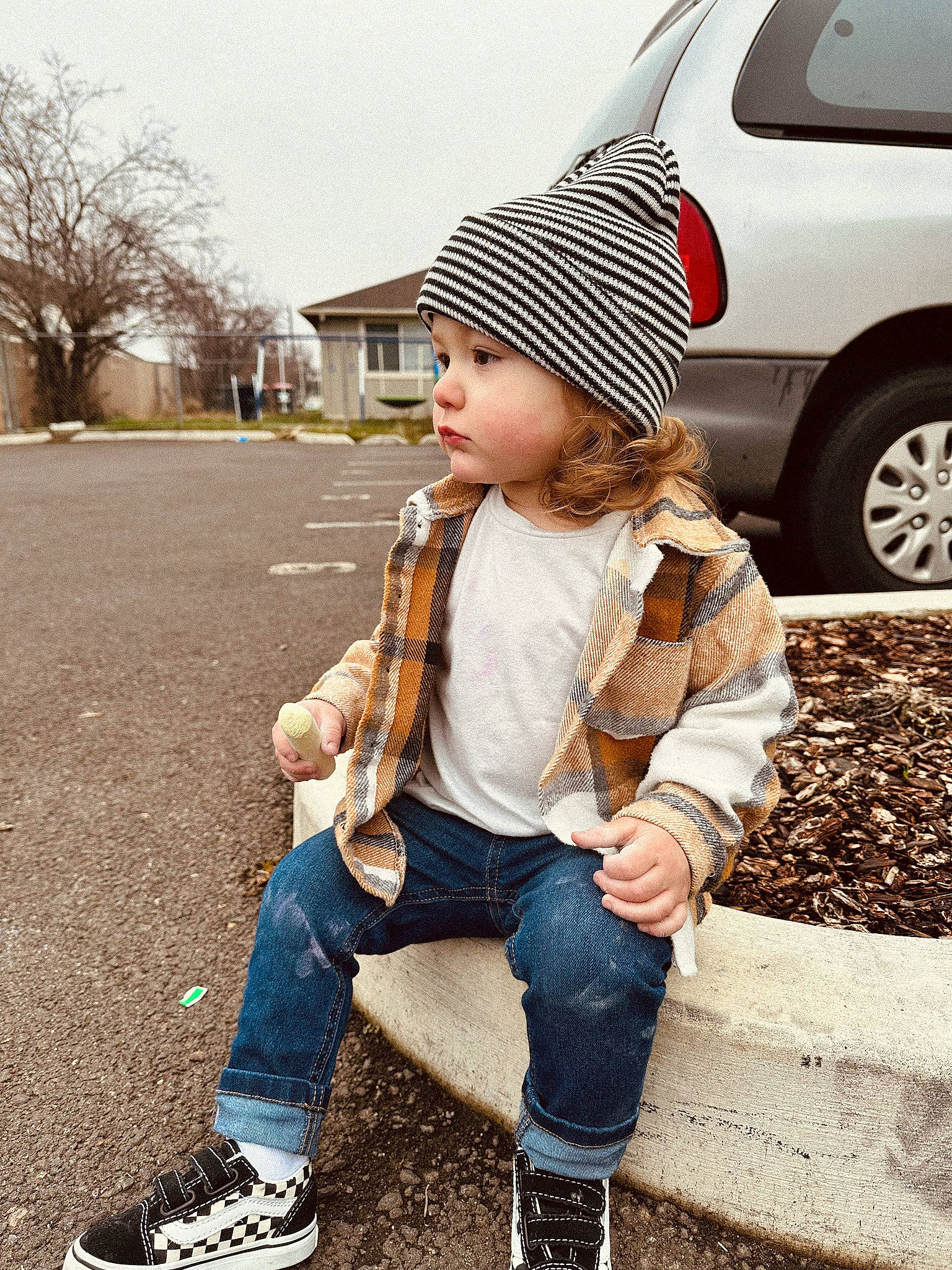 Alex is registered to the contest to win money with this photo: asphalt, cap, car, face, footwear, hand, hat, headwear, jacket, jeans, outerwear, person, plant, road_surface, shoe, sneakers, tire, toddler, tree, vehicle