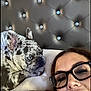 Prada is registered to the contest to win money with this photo: dog, french_bulldog, spotted_dog, pet, bed, headboard, pillow, woman, glasses, face, resting, indoor, closeup, portrait, relaxing, cozy, sleepy, cute, animal, companion