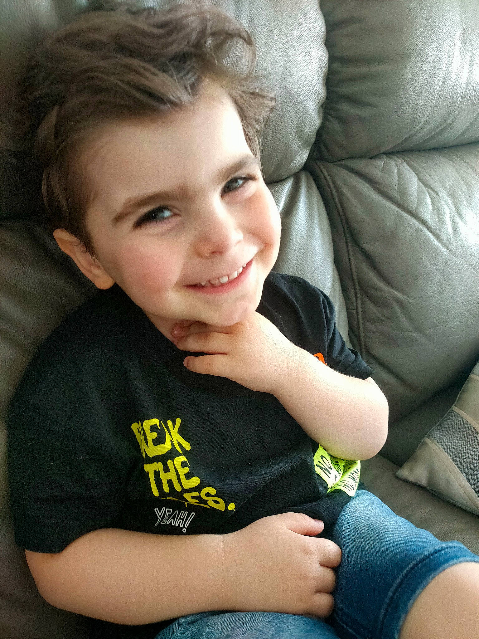 David participe au concours pour gagner de l'argent avec cette photo : cheek, child, comfort, couch, elbow, eye, flash_photography, gesture, happy, human_body, joy, lip, neck, nose, person, shoulder, skin, sleeve, smile, t_shirt