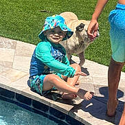 Oakley joined the competition — help win amazing prizes! child, pool, water, swimwear, hat, dog, grass, sidewalk, sunny, outdoor, happy, smile, barefoot, person, summer, playing, pet, blue, sitting, fun