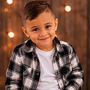 Oakley joined the competition — help win amazing prizes! child, boy, smile, plaid_shirt, white_tshirt, portrait, indoors, warm_lighting, soft_light, head_and_shoulders, happy, cute, haircut, casual_clothing, background_lights, warm_colors, young_boy, friendly_expression, fashion, cozy