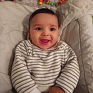Naël participe au concours pour gagner de l'argent avec cette photo : baby, smiling, infant, striped_sweater, baby_seat, toys, colorful, happy, child, cute, indoor, cozy, hands, face, portrait, comfort, soft, cushion, play, young