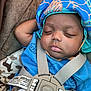 Kameran is registered to the contest to win money with this photo: baby, sleeping, hat, blue_shirt, car_seat, straps, cushion, camouflage, closeup, infant, child, peaceful, resting, face, indoors, comfort, seatbelt, headwear, portrait, soft_lighting