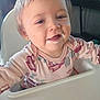 baby, child, cute, face, feeding_time, floral_pattern, food_on_face, happy, head, high_chair, indoors, long_sleeve, messy, person, pink_clothing, portrait, sitting, smiling, toddler, young_child