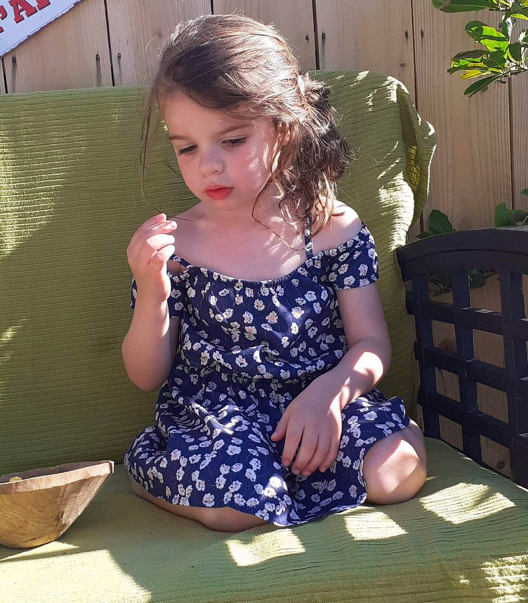 Lena participe au concours pour gagner de l'argent avec cette photo : child, dress, electric_blue, facial_expression, fun, grass, hairstyle, happy, human_body, human_leg, knee, lap, leisure, long_hair, pattern, person, plant, shoulder, sitting, t_shirt