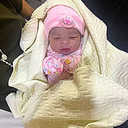 Eliana is registered to the contest to win money with this photo: newborn, baby, infant, sleeping, pink_hat, kitty_hat, mittens, blanket, swaddled, portrait, face, indoors, cozy, clothing, textile, cream_blanket, seated, car_seat, cuddled, photography