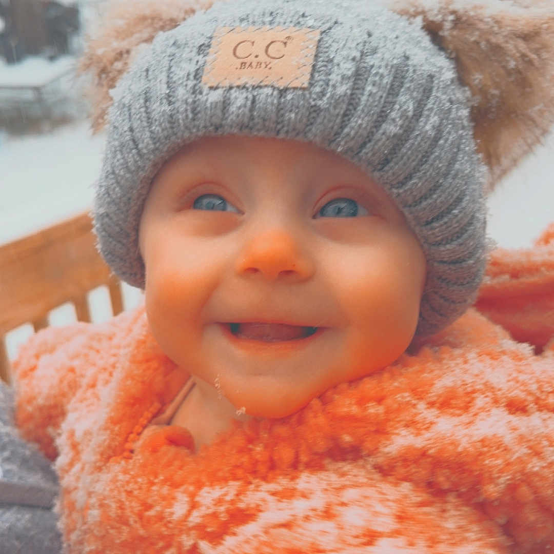 Astrid joined the competition — help win amazing prizes! baby, beanie, bonnet, cap, clothing, coat, face, glove, happy, hat, head, hood, jacket, nature, outdoors, person, photography, portrait, smile, snow
