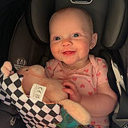 Evelyn joined the competition — help win amazing prizes! baby, child, car_seat, plush_toy, fabric_book, smiling, happy, infant, pink_clothing, heart_pattern, seatbelt, cute, indoor, portrait, person, childhood, toy, young, sitting, bright