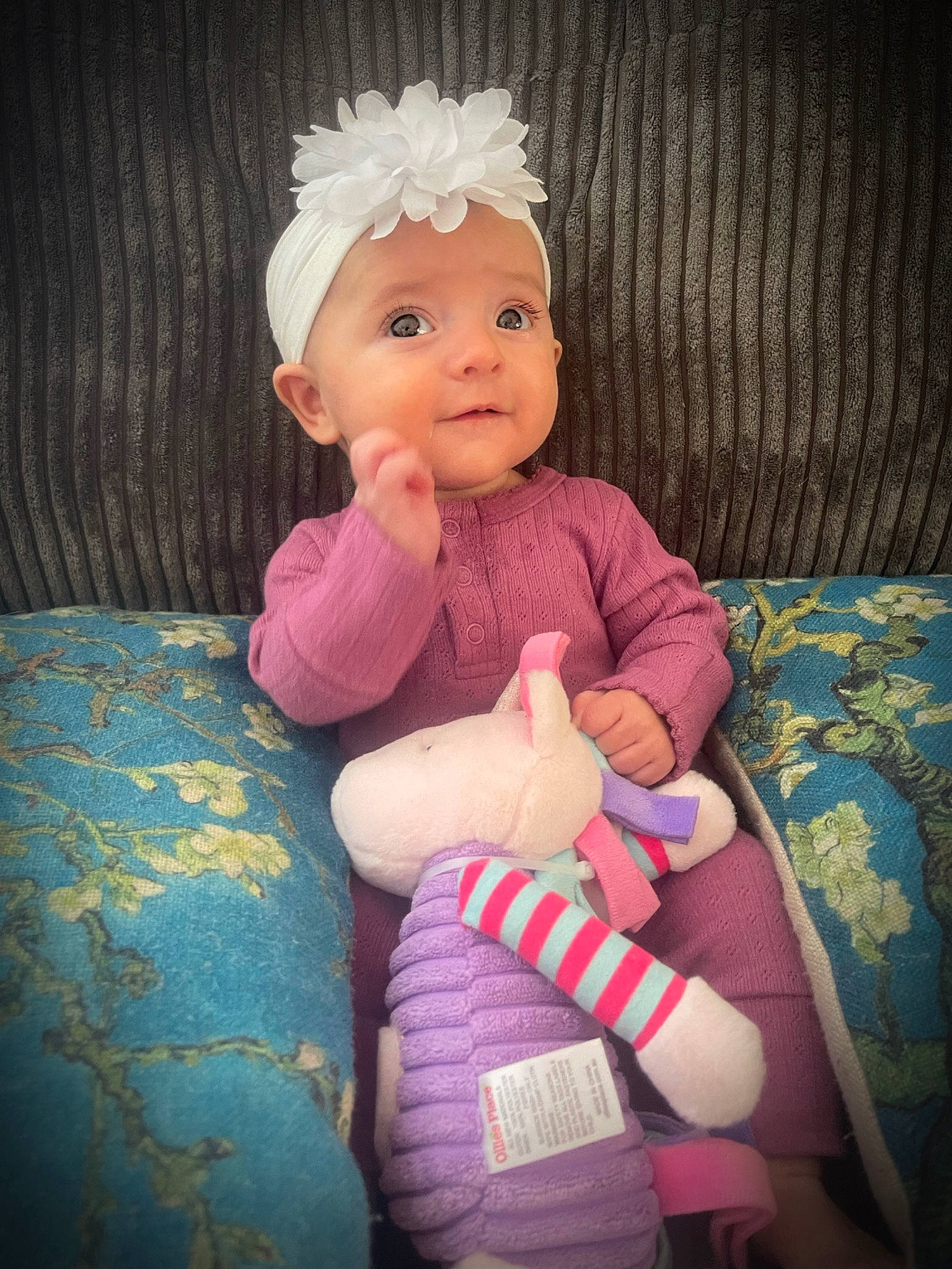 Darcie is registered to the contest to win money with this photo: arm, baby, baby_toddler_clothing, cheek, child, comfort, eye, finger, happy, head, headwear, human_body, magenta, nail, person, pink, purple, skin, sleeve, sock