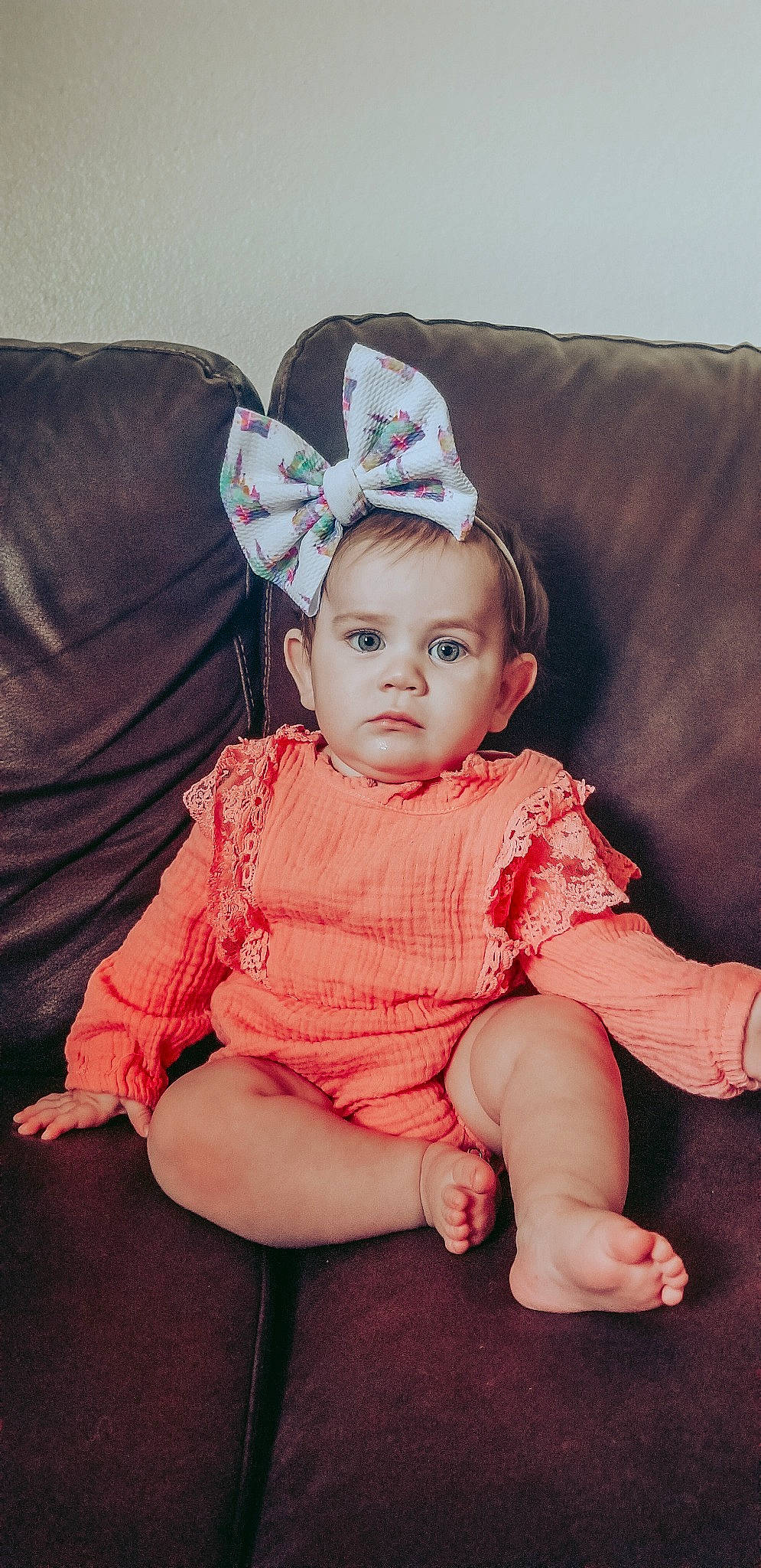 Averi is registered to the contest to win money with this photo: baby, cheek, child, ear, fashion_accessory, hair_accessory, head, headgear, iris, person, pink, sitting, smile, toddler