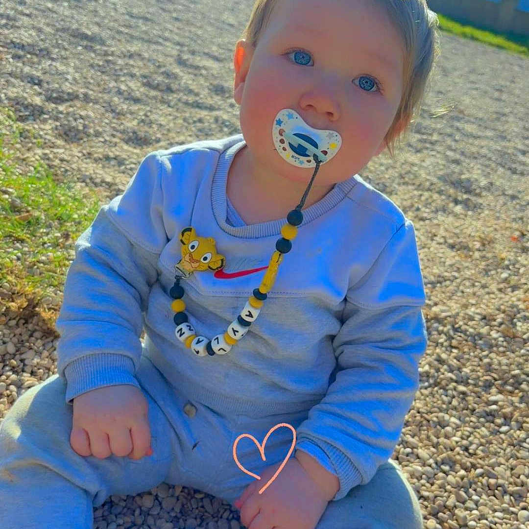 Aylan a rejoint le concours — aidez-le/la à gagner de superbes lots ! accessories, baby, clothing, cream, face, grass, head, jewelry, nature, necklace, outdoors, pants, park, person, photography, plant, portrait, rock, sitting, soil