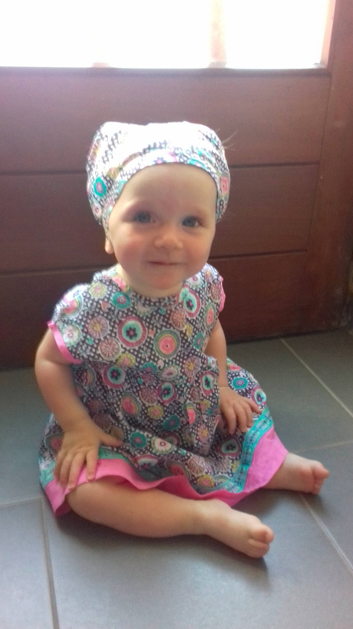 Molly a rejoint le concours — aidez-le/la à gagner de superbes lots ! art, baby, bonnet, child, fashion_accessory, hair_accessory, head, headgear, pattern, person, sitting, toddler, turban, turquoise