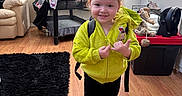 Mariah joined the competition — help win amazing prizes! child, toddler, girl, smiling, portrait, standing, indoor, home, hoodie, backpack, shoes, wooden_floor, black_rug, armchair, playpen, fan, storage_bin, window, daylight, happy