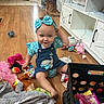 Dakota joined the competition — help win amazing prizes! toddler, child, baby, portrait, smiling, indoor, playroom, toys, stuffed_animal, bow, headband, polka_dot, dress, denim, overalls, sitting, wood_floor, furniture, makeup_palette, home