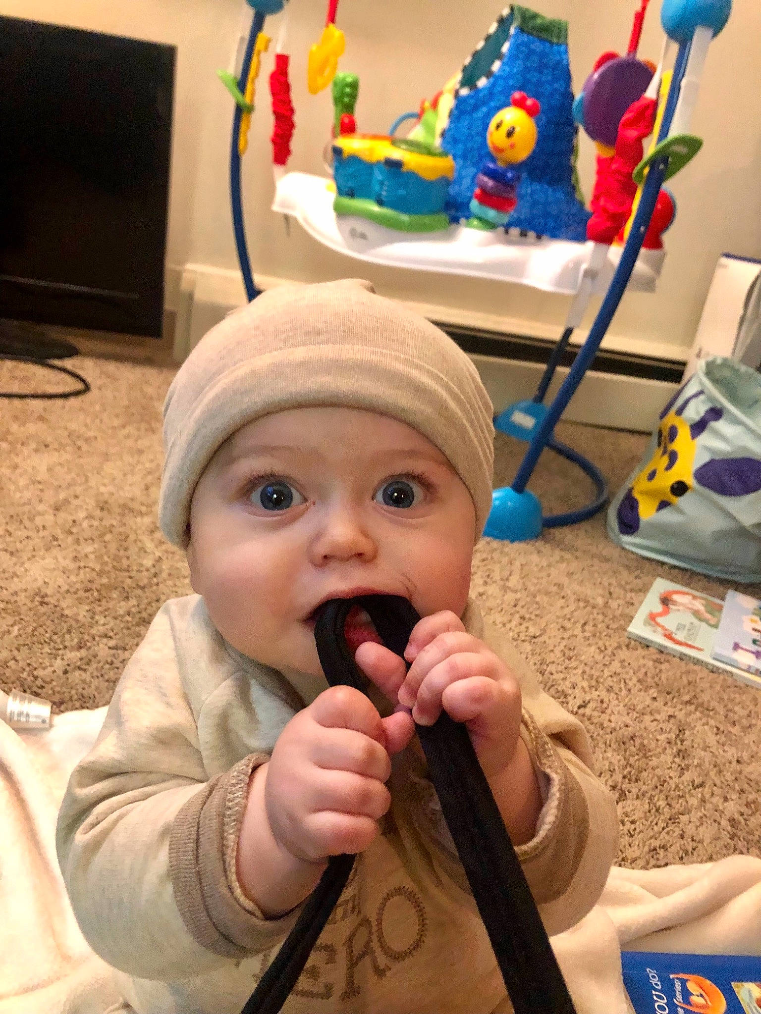 Phoenix is registered to the contest to win money with this photo: art, baby, baby_toys, cap, cheek, child, event, flooring, fun, headgear, headwear, helmet, kindergarten, party_supply, person, personal_protective_equipment, play, room, sitting, thumb