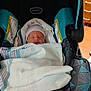 newborn, baby, infant, car_seat, blanket, hat, sleeping, indoors, hospital, child, person, bedroom_furniture, fabric, comfort, rest, cute, bundle, pattern, soft, peaceful