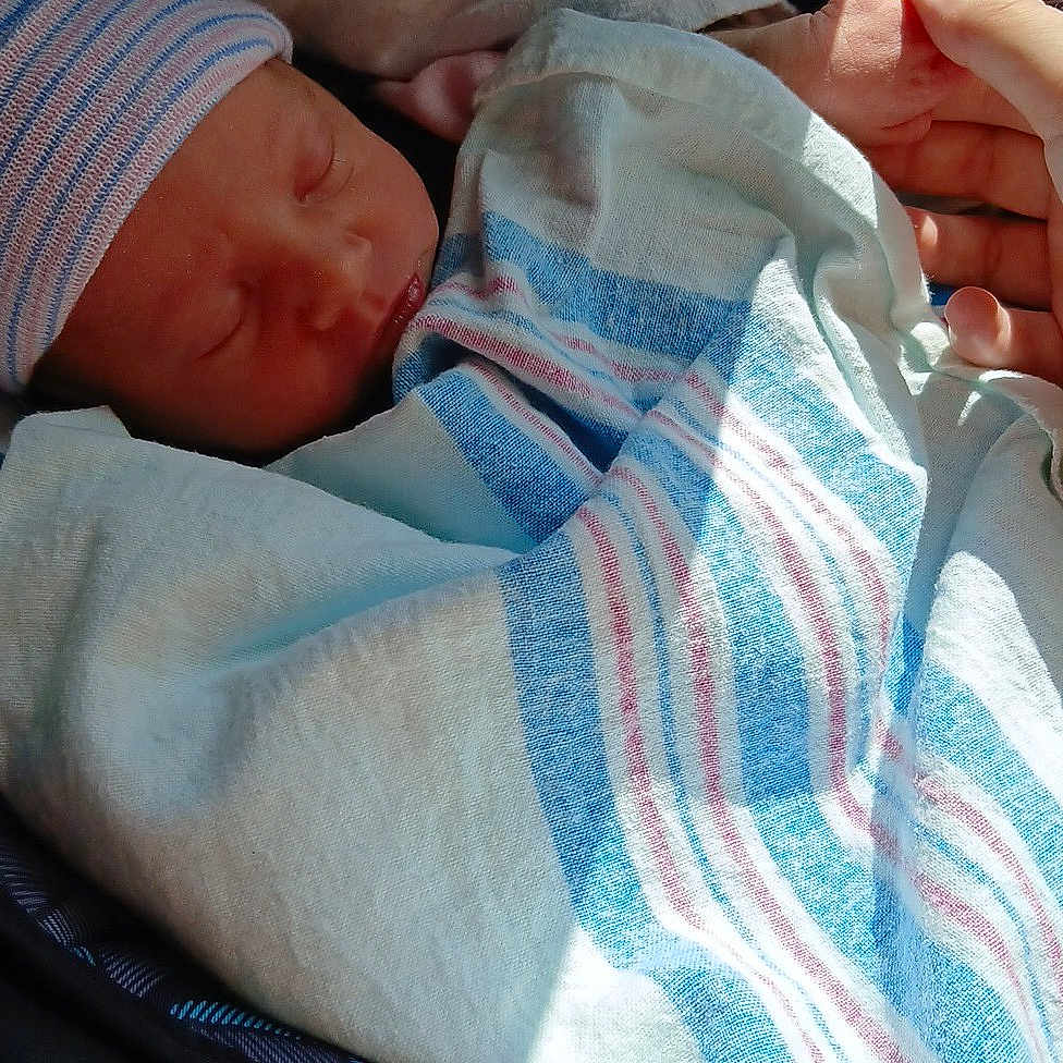 Ava joined the competition — help win amazing prizes! baby, blanket, car_seat, care, child, close_up, cozy, hand, hospital_blanket, indoor, infant, newborn, peaceful, person, portrait, resting, sleeping, striped_cap, swaddled, warning_label