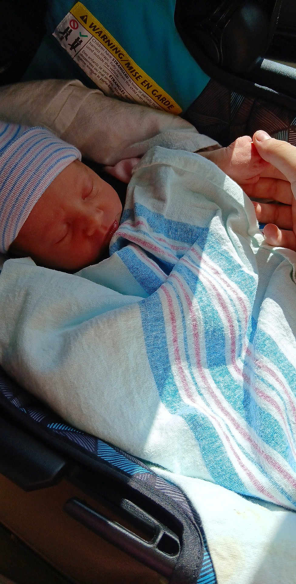Ava joined the competition — help win amazing prizes! newborn, baby, sleeping, swaddled, blanket, striped_cap, car_seat, hand, warning_label, infant, cozy, hospital_blanket, child, peaceful, portrait, close_up, person, indoor, resting, care