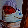newborn, baby, sleeping, hospital, blanket, hat, crib, infant, swaddled, bed, child, person, sleep, cute, soft_lighting, striped_hat, newborn_baby, wrapped, cozy, peaceful