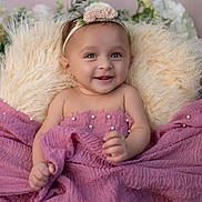 Sridha joined the competition — help win amazing prizes! baby, smiling, blanket, pink, headband, flower, fluffy, pillow, cute, portrait, child, happy, infant, closeup, indoors, soft_texture, decor, person, wrapped, skin
