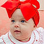 baby, infant, child, headband, red_bow, blue_eyes, white_dress, embroidery, portrait, closeup, cute, adorable, face, skin, young, fashion, accessory, soft_background, indoor, smiling