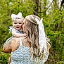 baby, woman, kiss, bow, hair, lace, tattoo, greenery, outdoor, nature, dress, pattern, smile, happy, child, mother, affection, holding, portrait, person