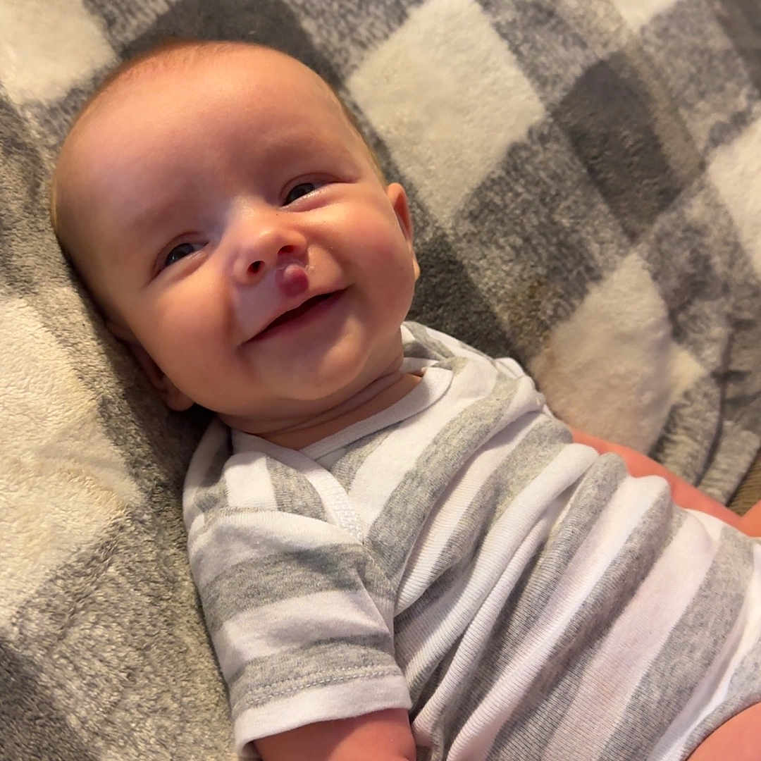 Nolan joined the competition — help win amazing prizes! baby, bed, bedroom, blanket, clothing, cushion, face, furniture, happy, head, homedecor, indoors, newborn, person, photography, portrait, quilt, room, smile, t_shirt