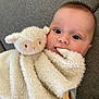 Paul a rejoint le concours — aidez-le/la à gagner de superbes lots ! baby, child, plush_toy, lamb, stuffed_animal, soft_toy, couch, indoor, face, eyes, mouth, blanket, fabric, comfort, cute, snuggle, nibble, infant, person, cozy