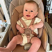 Elise a rejoint le concours — aidez-le/la à gagner de superbes lots ! baby, infant, high_chair, smiling, happy, indoor, child, straps, seat, person, furniture, home, kitchen, legs, face, cute, skin, expression, sitting, young